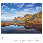 Monatsname und Kalendertage. Landschaft mit Bergen, spiegelndem See und blauem Himmel.