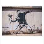 "happyland tatars" steht links. Eine Graffiti-Illustration zeigt eine vermummte Person, die einen Blumenstrauß wirft.