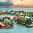 Kalender für Juni und Juli, Text über »Lagunenstadt« Oak Ridge. Bunte Häuser am Wasser und tropische Vegetation.