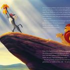 Eine Illustration zeigt einen Affen, der ein Löwenjunges auf einem Felsen in die Luft hält, daneben stehen zwei erwachsene Löwen.