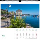 Der Kalender zeigt den Monat Mai. "3" und ein Gebäude am Wasser mit Boots-Anlegern und Pflanzen im Vordergrund.