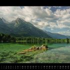 2027, Kalenderblatt Mai. Klares Wasser und bewaldete Berglandschaft unter teils bewölktem Himmel.