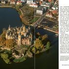 "Luftaufnahme der Schweriner Schlossinsel. Schloss von Wasser umgeben, umgeben von Gärten und herbstlichen Bäumen."