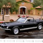 Text: "1986er Ford Mustang Shelby GT500KR 428 Cobra Convertible." Schwarzes Cabrio vor mediterranem Gebäude.