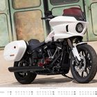 "Harley Davidson" auf weißem Motorrad vor grüner Wand. Unten ein Kalender für Mai mit hervorgehobenen Sonntagen.