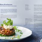 Text beschreibt ein Rezept für "Caponata siciliana di melanzane". Gericht aus Auberginen und Burrata, mit Pinienkernen garniert.