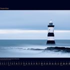 12 Dezember. Kalenderseite mit Foto eines Leuchtturms im Meer, umgeben von nebligem Wasser und kühlblauem Himmel.