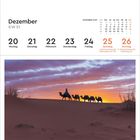 Dezember KW 51. Kalender mit Wochentagen 20-26. Kamele in einer Wüste bei Sonnenuntergang im Hintergrund. Ort: Marokko.