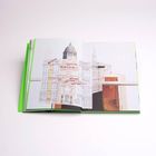 Offenes Buch mit grünem Einband, zeigt stilisiertes Bild eines Gebäudes mit Kuppel und Texten darüber.