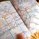 Eine detaillierte Karte zeigt Bahnhöfe wie Paddington, Baker Street und King's Cross. Mehrere Linien in verschiedenen Farben.