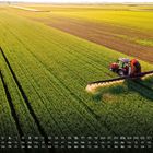 Kalender unteres Drittel, Tage und Wochentage aufgeführt. Traktor besprüht ein großes grünes Feld.