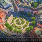 Gärtnerplatz, Kalenderdarstellung mit Tagen und Wochentagen im Juli. Luftaufnahme eines runden Parks mit Blumenbeeten.