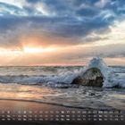 Kalender: Tage und Datumsangaben im Mai. Meer mit Sonnenuntergang, Wellen schlagen gegen einen Felsen.