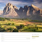 Kalender: 46. Woche, November 2027. Landschaft: Grüne Wiesen, Kiefern und majestätische Berge im Hintergrund.