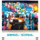 "November - Dezember" in blauer Schrift, Straßenbild einer belebten Metropole mit Neonlichtern, Regenschirmen und einem Taxi.