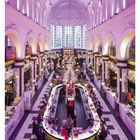 51 DEZEMBER Kalenderwoche mit Weihnachtsmarkt in einer beleuchteten Halle, zentrale Bar, dekoriert mit Lichtern.