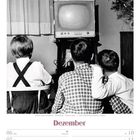 Text: „Dezember, KW49/2027“. Drei Kinder schauen im 1950er-Jahre-Stil Fernsehen. Links ein Vorhang, rechts ein Weihnachtsbaum.