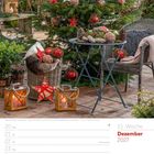 Dezember 2027, 51. Woche. Ein geschmückter Christbaum auf einer Terrasse mit Kerzen, Laternen und Dekorationen.