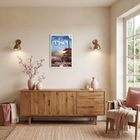 „Reisen 2027“ steht auf einem Kalender an der Wand. Ruhige Wohnzimmer-Szene mit Holzmöbeln und blühenden Zweigen in Vasen.