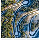 52. Woche 2027, DEZ/JAN: Kurvige Straße durch einen schneebedeckten Wald.