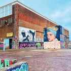 „MAKE ART NOT€“ in großen orange Buchstaben an der Backsteinwand, farbenfrohe Graffiti und eine Frau mit Turban gemalt.