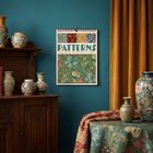 Text: "PATTERNS. Magische Muster - Wochenplaner 2027 - 50 Blatt." Ein Wandkalender mit floralen Mustern hängt an einer Wand.