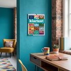 „klartext“, umgeben von gemütlichem Raum: Blauer Wandkalender, gelber Sessel, Schreibtisch, bunte Tasse und Pflanzen.