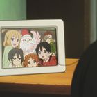 Ein digitaler Bilderrahmen zeigt lächelnde Anime-Charaktere, darunter ein Vogel im Weihnachtsmannkostüm.