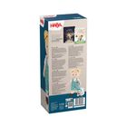 HABA Logo, Buch „Mein Knopf, ein Universum“. Beschreibung der Puppe in mehreren Sprachen. Illustration eines Kindes mit Teddybär.
