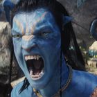 Keine Texte sichtbar. Ein Wesen mit blauer Haut und Raubtierzähnen schreit, umgeben von Felsen und Pflanzen.