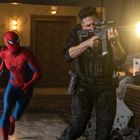 Ein Mann in einem schwarzen Kampfanzug schießt mit einem Gewehr. Neben ihm läuft jemand im Spiderman-Kostüm. Umfeld zerstört.