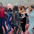 Ein fröhliches Tanzszenario bei einer Party: viele Menschen tanzen umgeben von rosa Ballons.