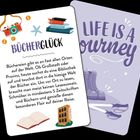 "BÜCHERGLÜCK" und "LIFE IS A JOURNEY" stehen im Vordergrund. Eine Kamera, Bücher und ein Hotel sind abgebildet.