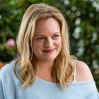 Es gibt keinen sichtbaren Text. Eine lächelnde Frau mit langen blonden Haaren, umgeben von unscharfem Grün im Hintergrund.