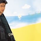 Kein Text im Bild. Ein Mann in schwarzer Kleidung zeigt energisch auf den Betrachter. Hintergrund: Gelber Sand, blauer Himmel.