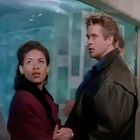 Der Text: keiner erkennbar. Zwei Personen schauen ernst, eine Frau mit kurzen Haaren, ein Mann mit hellem Haar.