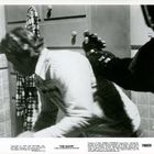 „THE GLOVE“ A PRO INTERNATIONAL RELEASE. Ein Mann in einem weißen Pullover wird von einer gepanzerten Hand bedroht.