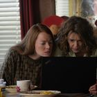 Zwei Frauen schauen konzentriert auf einen Laptop-Bildschirm. Der Laptop trägt die Aufschrift "ThinkPad". Auf dem Tisch stehen Tassen und Teller.