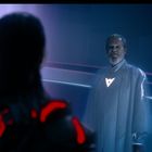 Person mit leuchtendem Symbol auf Kleidung, futuristische Umgebung mit neonfarbenen Linien.