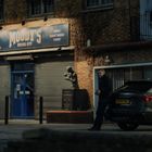 Der Eingang zu einem Boxstudio mit dem Schild "MOODY'S BOXING GYM". Ein Mann steht neben einem dunklen Auto auf der Straße.