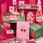 Texte: "Student", "Fruity Love", Bild voll von Kirschen-Motiven, viele rosa und rote Schulsachen auf grünem Tisch.