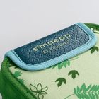 Der Text "s'maepp BY BRUNNEN" steht auf einem blauen Lederetikett. Darunter florale Muster auf grüner Textur.