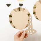 Kein Text. Eine Hand hält eine papierene Löwenmähne mit geometrischen Formen. Verspieltes, minimalistisches Design.