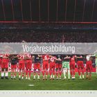 Vorjahresabbildung. Fußballteam in roten Trikots steht Arm in Arm im Stadion vor einer jubelnden Menge.