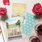 Buchhandlung, Bahnhof. Zwei Karten zeigen einen Buchladen und einen Bahnhof. Daneben liegen rote Rosen und ein Getränk mit Beeren.
