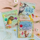 Drei Kinderbücher mit farbenfrohen Covern und Vogelillustrationen; Blumen und Federn liegen daneben.
