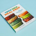 „FREEZE FRESH MEAL PREP“ Buch mit bunten, gefrorenen Gerichten als Stapel dargestellt.