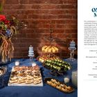 "ON THE MENU: A Welcome Toast, Three Ways, Salad on skewers, French fries, Blini with crème fraîche. Festliche Snacks." 

Festlich gedeckter Tisch mit Speisen, Blumen und Kerzen vor einer Ziegelwand.