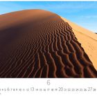 "6" und "CASARES EDITION" sind sichtbar. Eine Sanddüne mit Wellenstruktur unter einem klaren blauen Himmel.