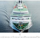 "Hurtigutenschiff auf See" und "CASARES EDITION". Ein großes, weißes Schiff fährt durch ruhiges Wasser, frontal gesehen.